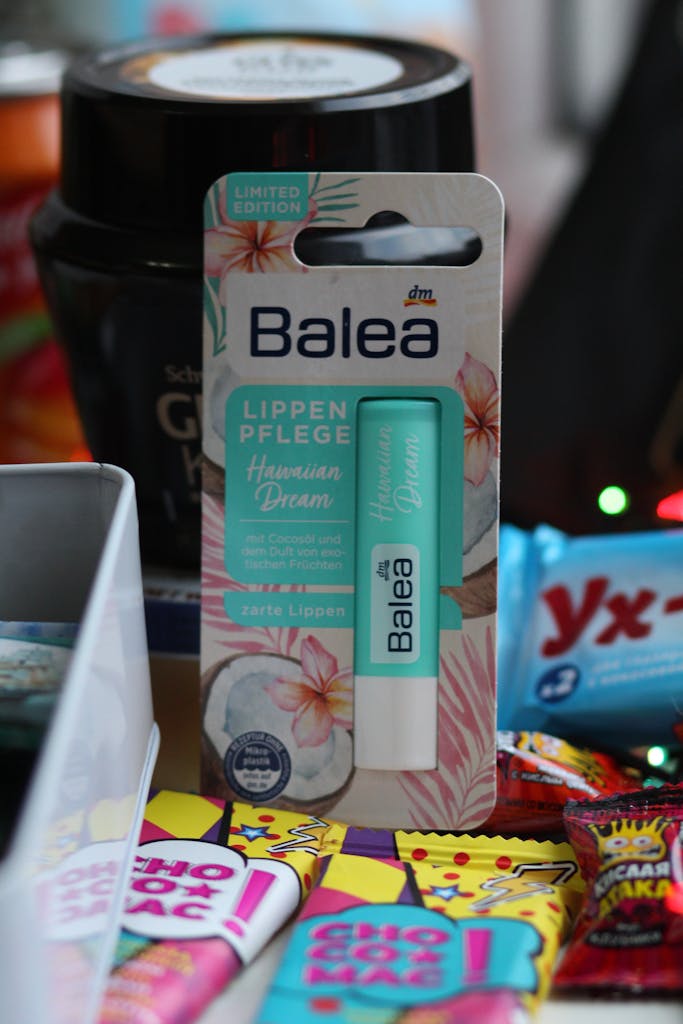 Vibrant Balea lip balm packaging surrounded by colorful snacks, ideal for self-care.